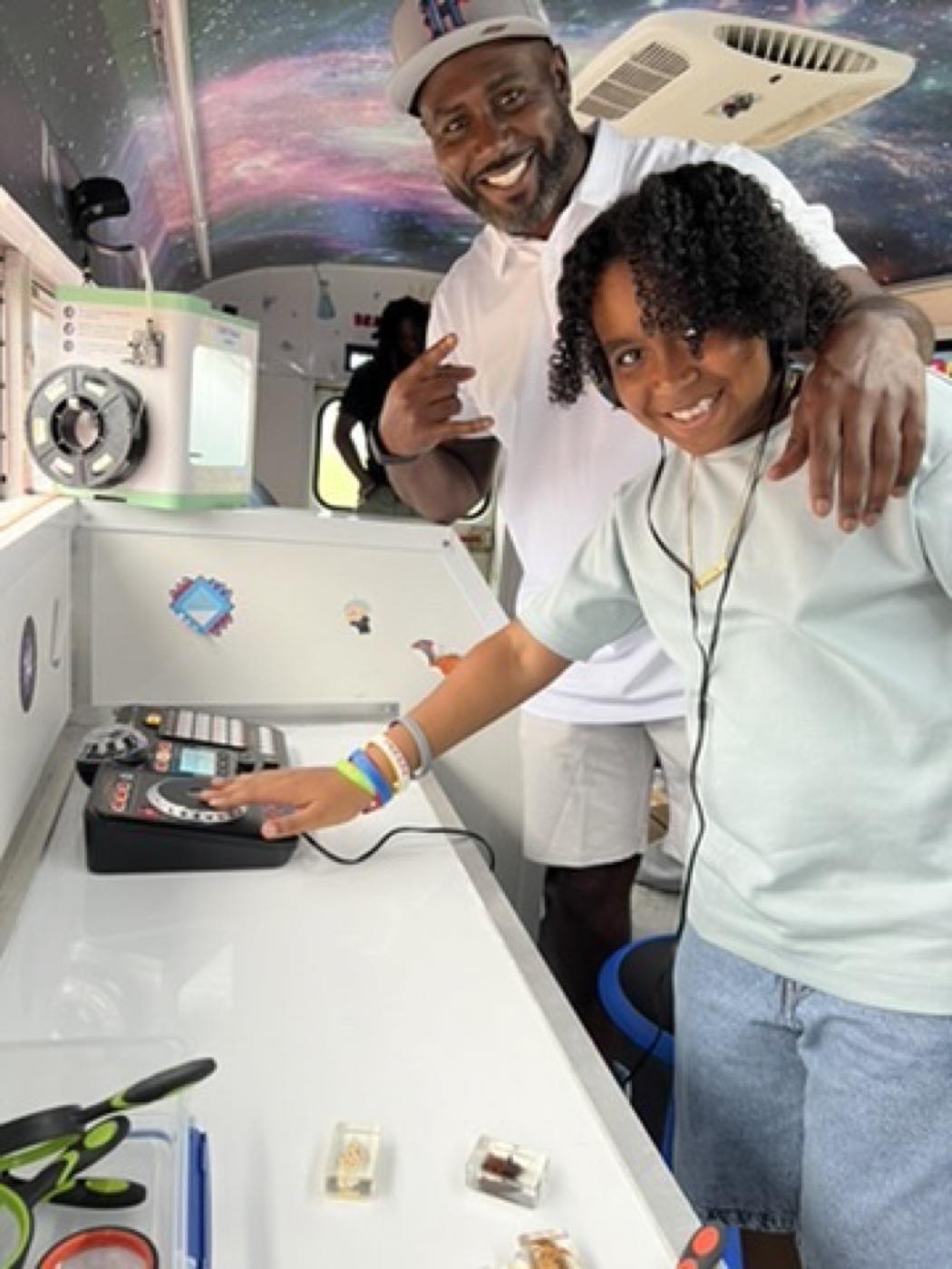 A parent and student at the sound and control station aboard the bus