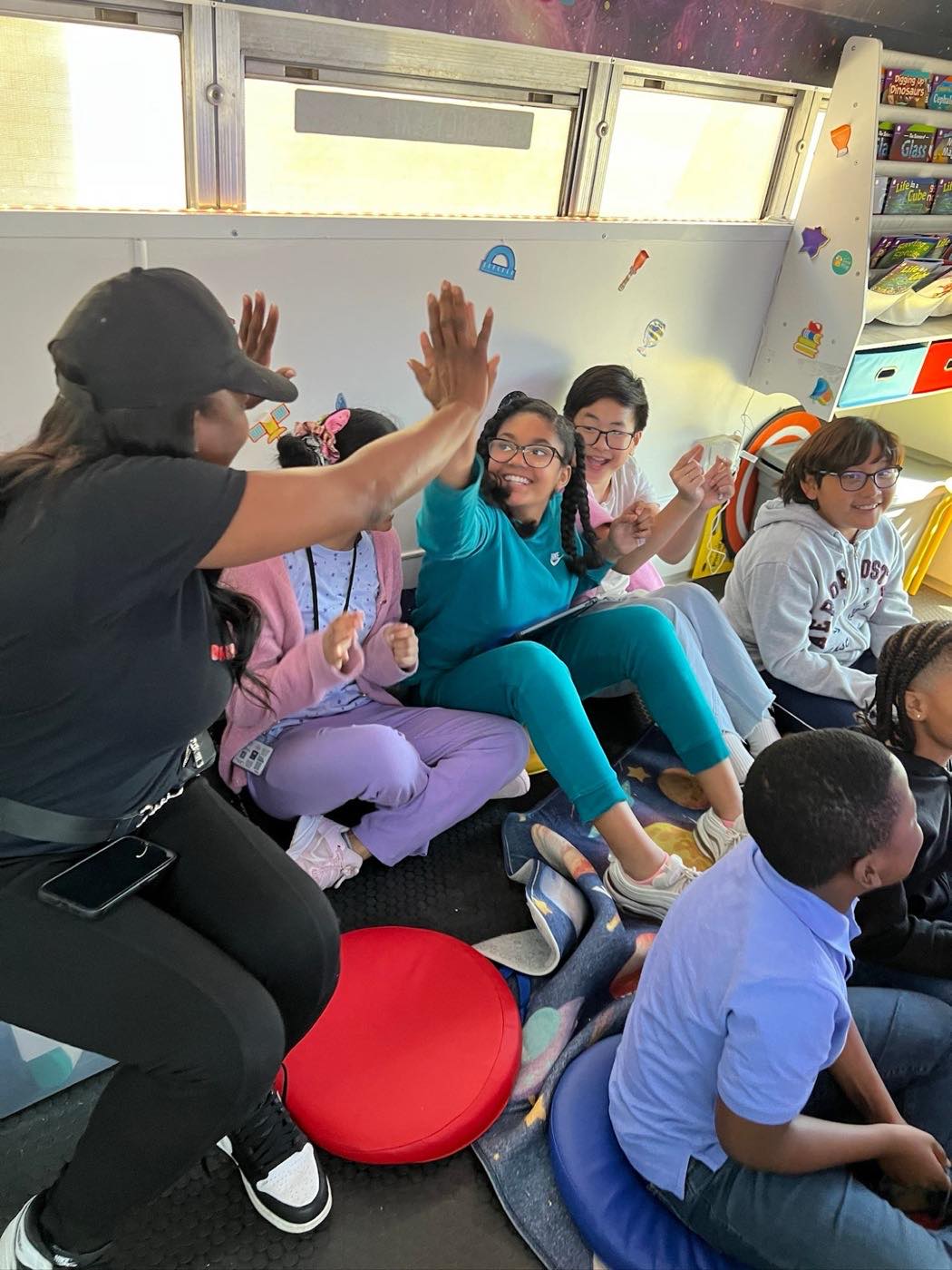 Students high-fiving their BrainBuzzed instructor at the end of a session on the bus