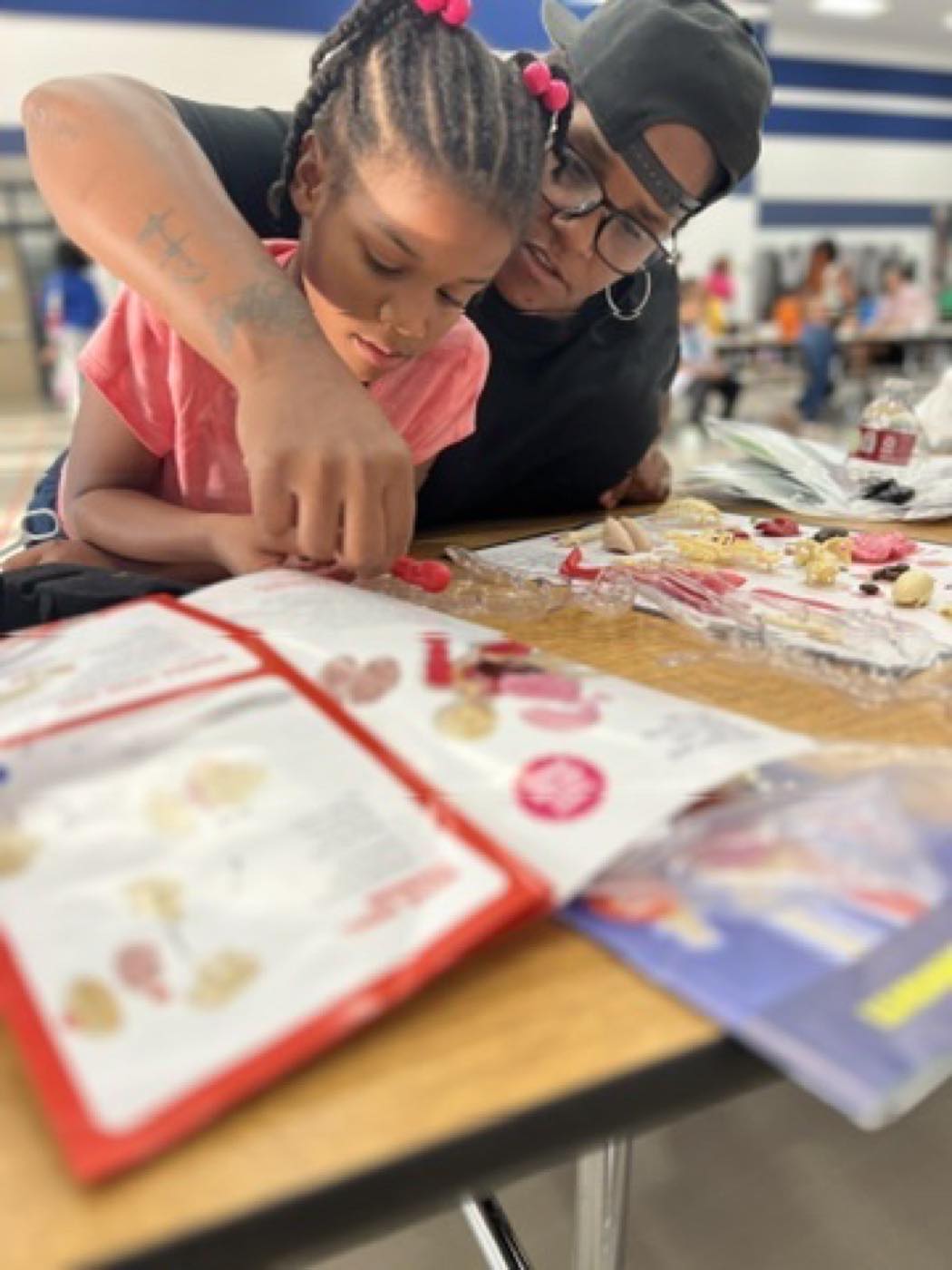 An instructor helping a student assemble a model kit at a family event