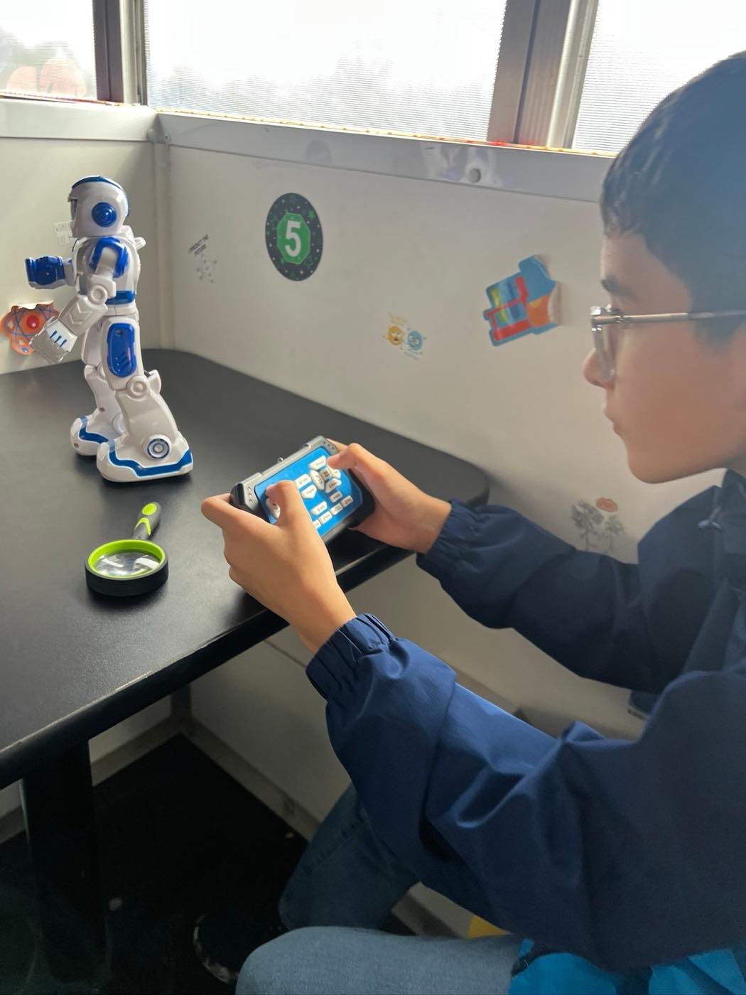 A student operating a programmable humanoid robot from a handheld controller